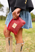 Girl holding small red stingray leather makeup bag