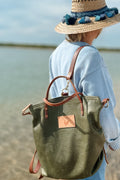 Woman wearing the Meanwhile Back on the Farm hunter green leather original backpack