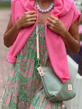 Woman wearing a seafoam green leather sling bag with the Meanwhile Back on the Farm logo and brass hardware