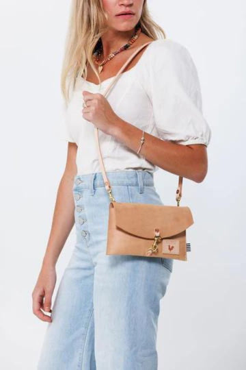 Girl holding Light Brown Leather Crossbody Envelope Bag with tan straps