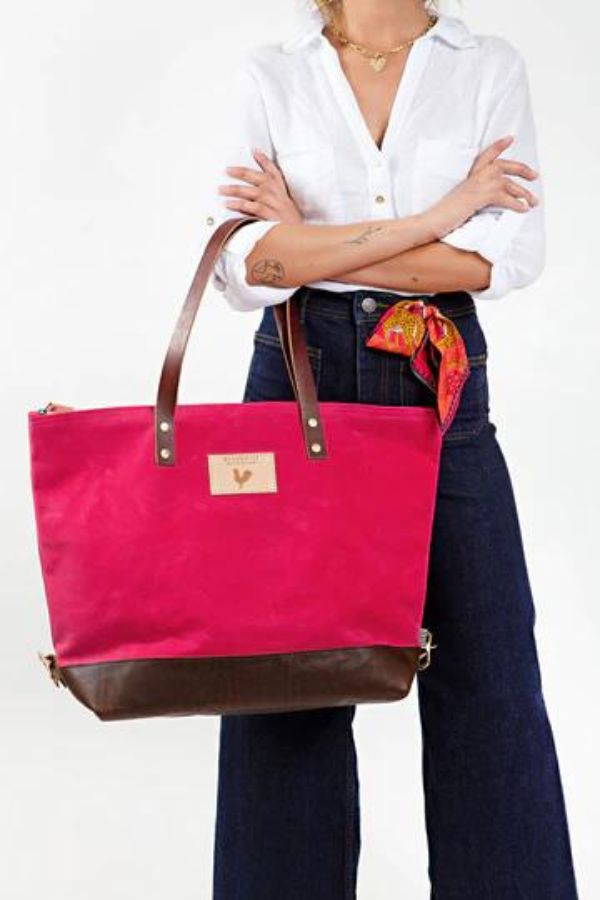 Girl holding large Pink Wax Canvas Adventure Tote with dark brown straps 