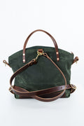 A dark green canvas tote bag with brown leather handles, a detachable brown shoulder strap, and gold-tone hardware, photographed on a clean white background. Handmade by Meanwhile Back on the Farm in Lynchburg,VA