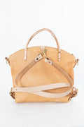 A light tan leather handbag with dual top handles and a detachable shoulder strap, photographed against a clean white background. Handmade by Meanwhile Back on the Farm in Lynchburg,VA