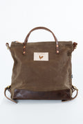 A brown waxed canvas tote bag with dark brown leather trim, top handles, and a front patch logo featuring a rooster.  Handmade by Meanwhile Back on the Farm in Lynchburg,VA