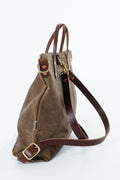 A brown suede and leather shoulder bag with gold-tone hardware, shown from a side angle on a white background. Handmade by Meanwhile Back on the Farm in Lynchburg,VA