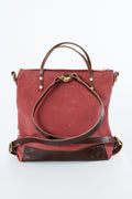 A red canvas tote bag with dark brown leather handles, trim, and bottom panel, featuring gold-tone hardware, photographed against a plain white background. Handmade by Meanwhile Back on the Farm in Lynchburg,VA
