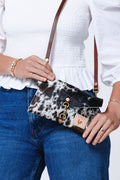 Picture of model displaying cowhide leather clutch with optional dark brown leather shoulder strap.