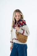 A woman wearing a cream knit sweater with a red and navy Fair Isle pattern, blue jeans, and carrying a brown suede crescent shoulder bag against a white studio background. Handmade by Meanwhile Back on the Farm in Lynchburg,VA