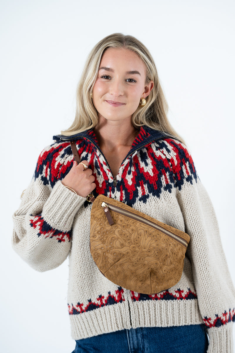 A woman wearing a cream knit sweater with a red and navy Fair Isle pattern, carrying a brown embossed faux-leather crossbody bag across her torso, set against a plain white studio background. Handmade by Meanwhile Back on the Farm in Lynchburg,VA