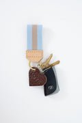 Keychain with heart-shaped charm and blue and tan striped key fob