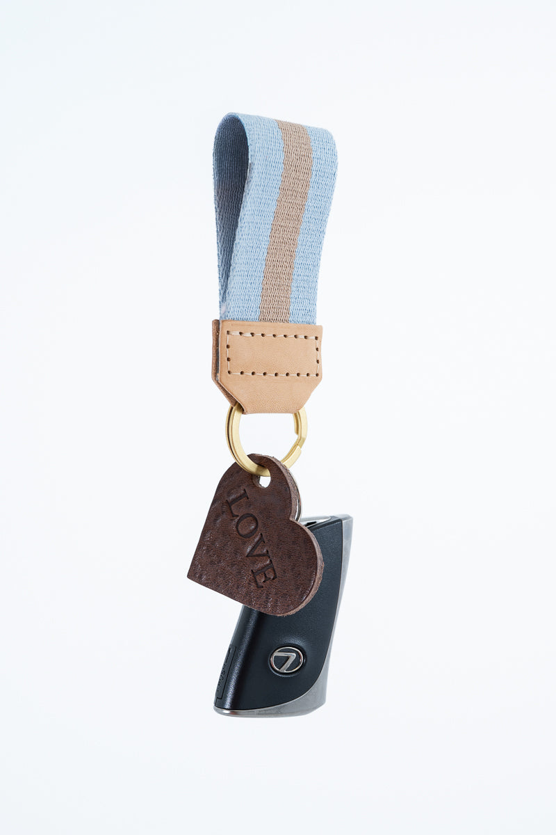 Keychain with heart-shaped charm and blue and tan striped key fob