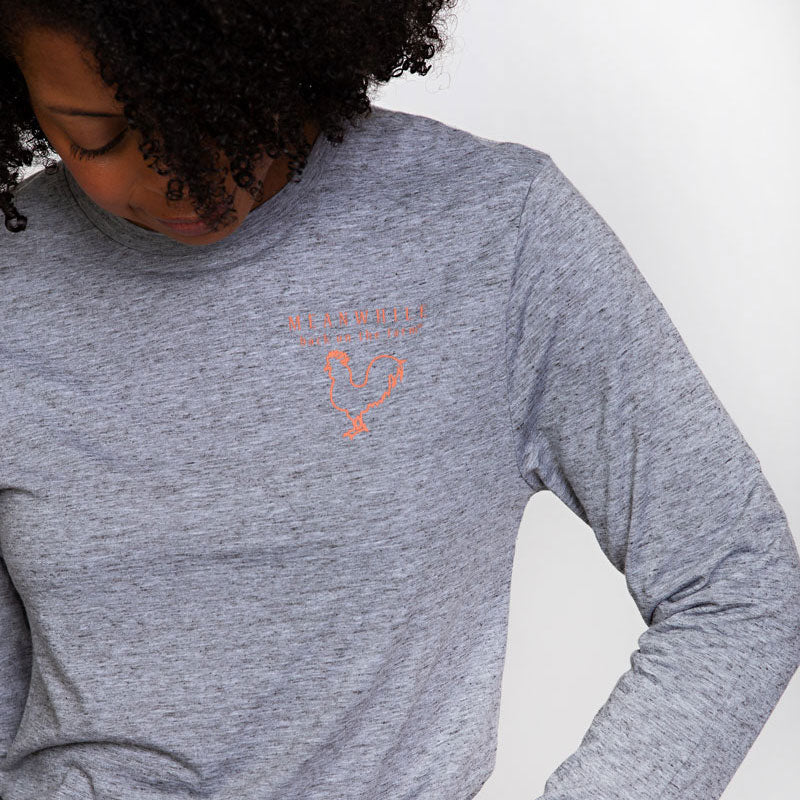 woman wearing the heather gray long sleeved t-shirt with meanwhile logo.