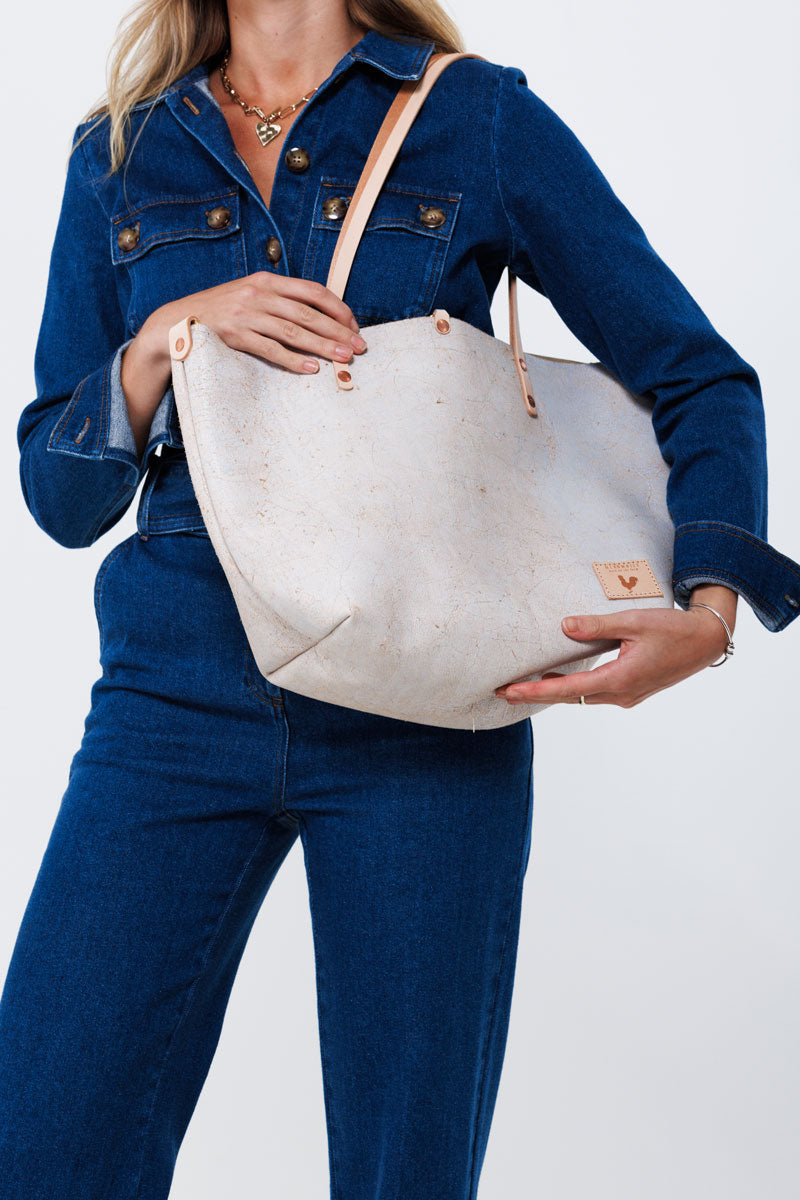 Young Woman holding Birth White Tote Bag with tan strap