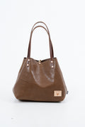 Brown leather handbag with a visible brand logo on a white background. Handmade by Meanwhile Back on the Farm in Lynchburg,VA