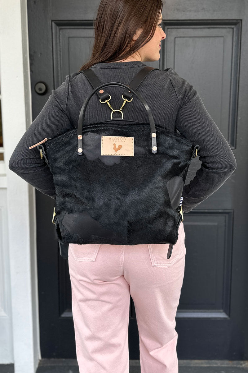 Girl wearing the Black Hair on Hide & Harness Leather Backpack 2.0 with black straps