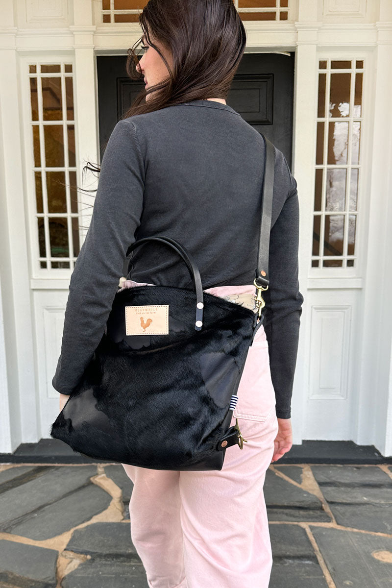 Girl wearing the Black Hair on Hide & Harness Leather Backpack 2.0 with black straps