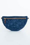 A navy blue quilted waist bag with an embossed floral pattern, featuring a gold-toned zipper and brown leather accents, set against a plain white background. Handcrafted by Meanwhile Back on the Farm in Lynchburg, Va.