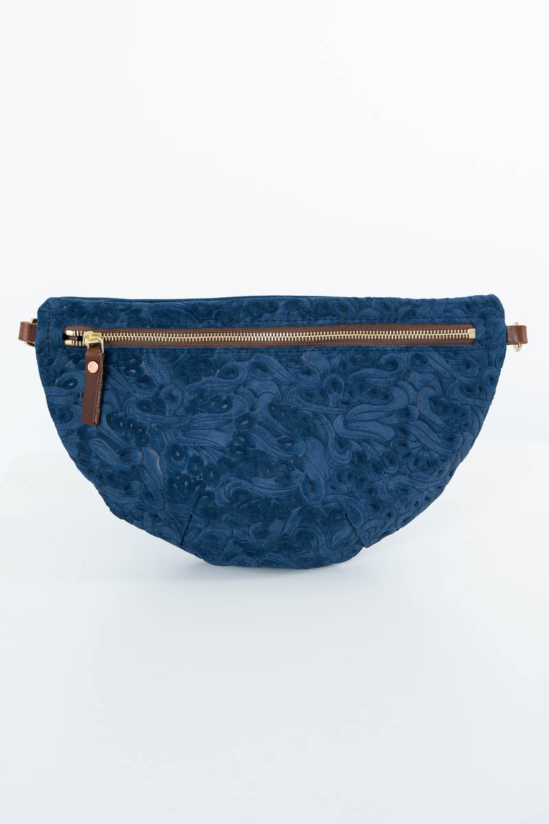 A navy blue quilted waist bag with an embossed floral pattern, featuring a gold-toned zipper and brown leather accents, set against a plain white background. Handcrafted by Meanwhile Back on the Farm in Lynchburg, Va.