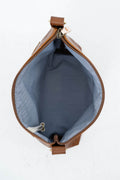 Top-down view of a brown leather bag showing its open interior with a blue-gray fabric lining and a zipper closure. Handcrafted by Meanwhile Back on the Farm in Lynchburg, Va.