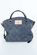 A blue-gray snakeskin-patterned handbag with black leather handles and a beige rectangular patch featuring a small rooster logo, photographed against a plain white background. Handcrafted by Meanwhile Back on the Farm in Lynchburg, Va.