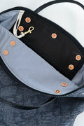 Close-up of the interior of a textured dark gray tote bag, showing a black zippered compartment with a light gray lining, copper-toned snap buttons, a white drawstring, and a gold-tone clip. Handcrafted by Meanwhile Back on the Farm in Lynchburg, Va.