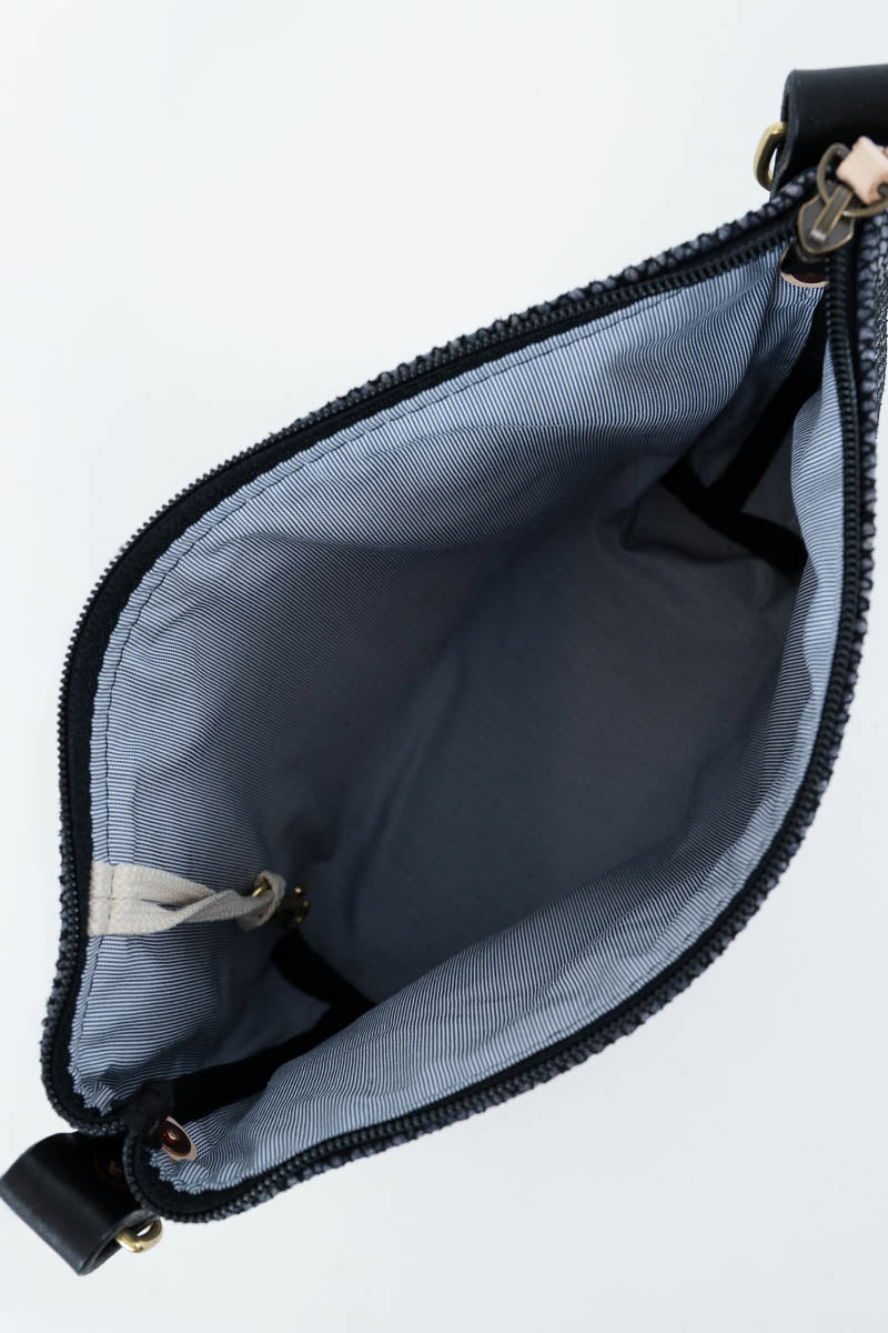 An open black zipper pouch showing a light gray fabric interior, photographed on a plain white background.