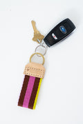 Colorful striped Meanwhile Back on the Farm webbing key fob with keys attached