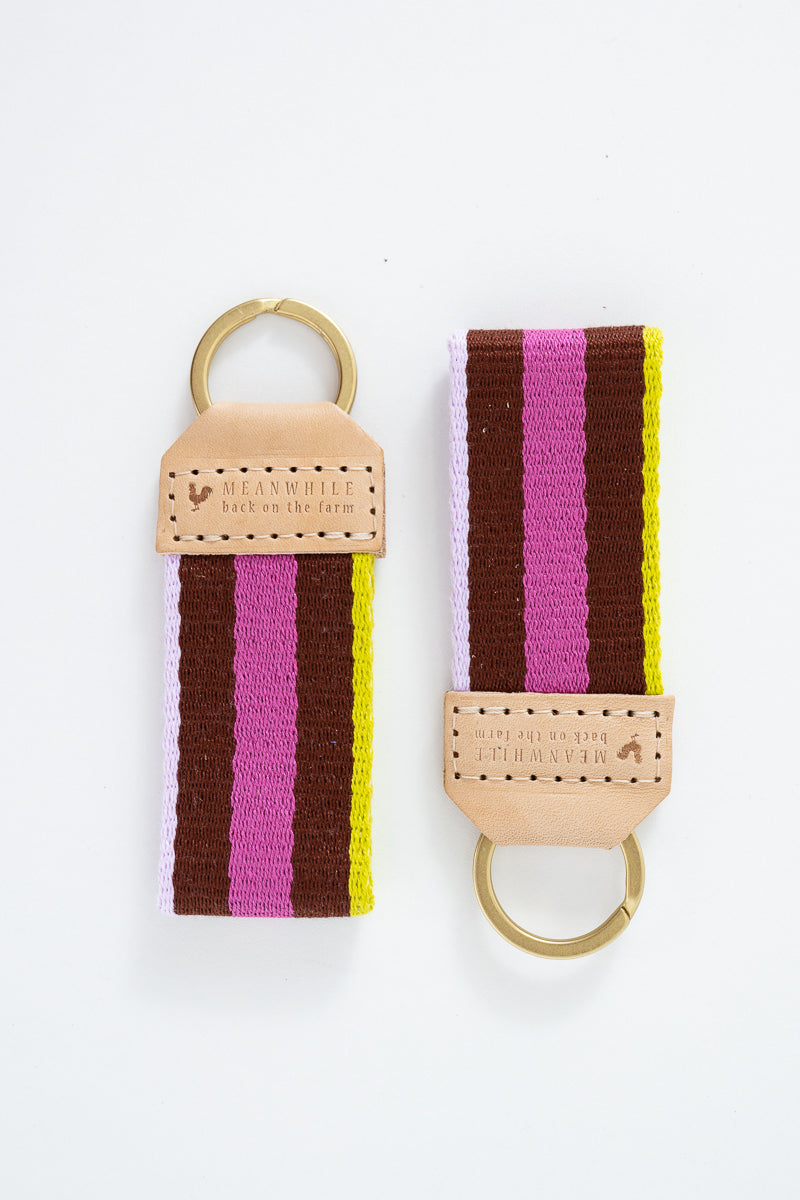 Two colorful striped Meanwhile Back on the Farm webbing key fobs