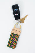 Colorful woven webbing Meanwhile Back on the Farm key fob attached to a key