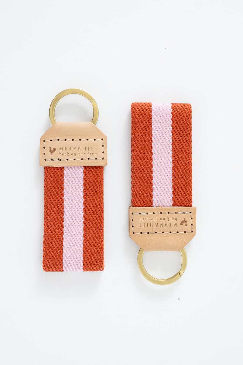 Two orange and pink striped Meanwhile Back on the Farm webbing key fobs