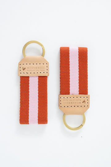 Two orange and pink striped Meanwhile Back on the Farm webbing key fobs