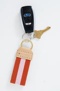 Orange and pink striped Meanwhile Back on the Farm webbing key fob with keys attached