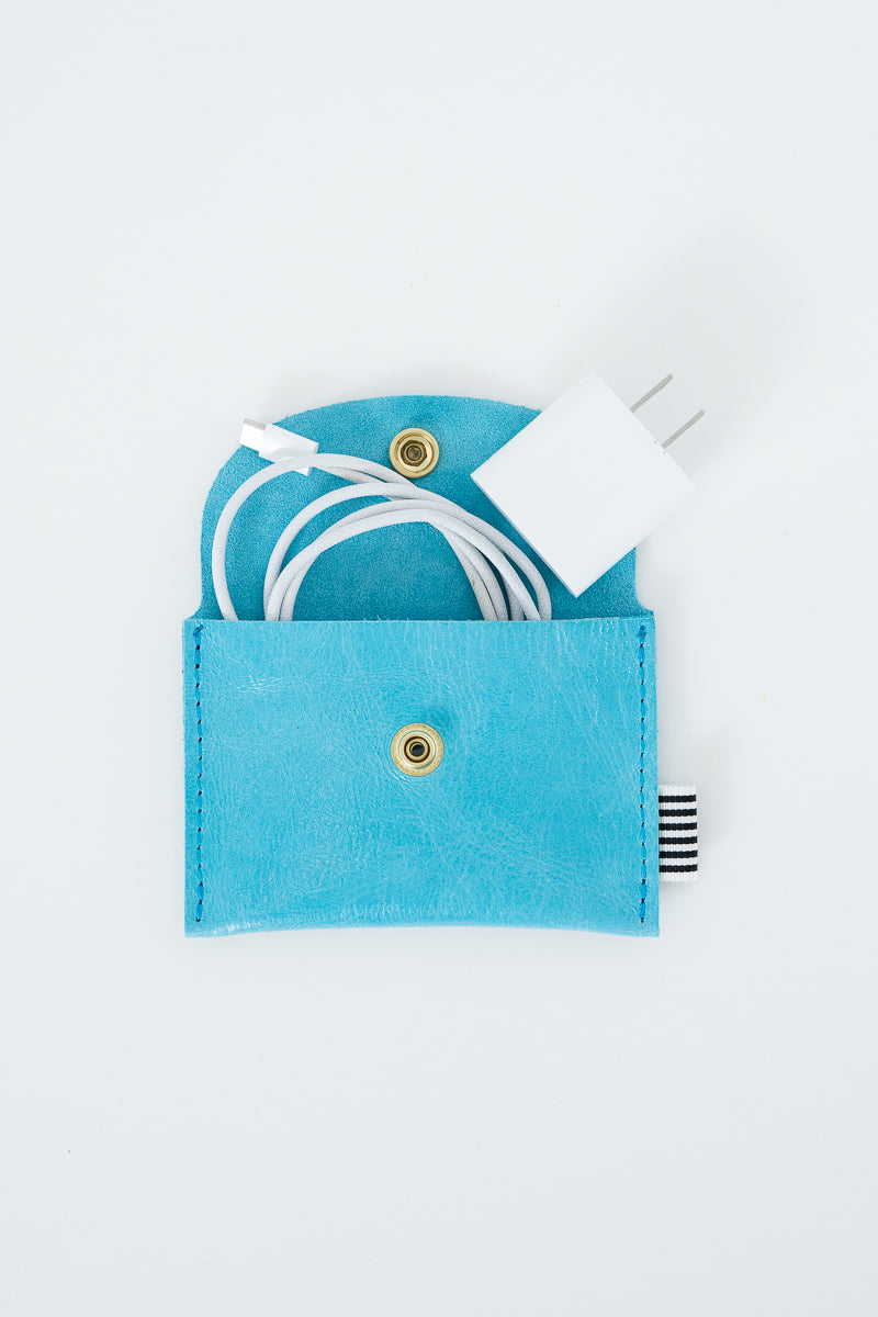 Blue snap pouch with a white phone charger