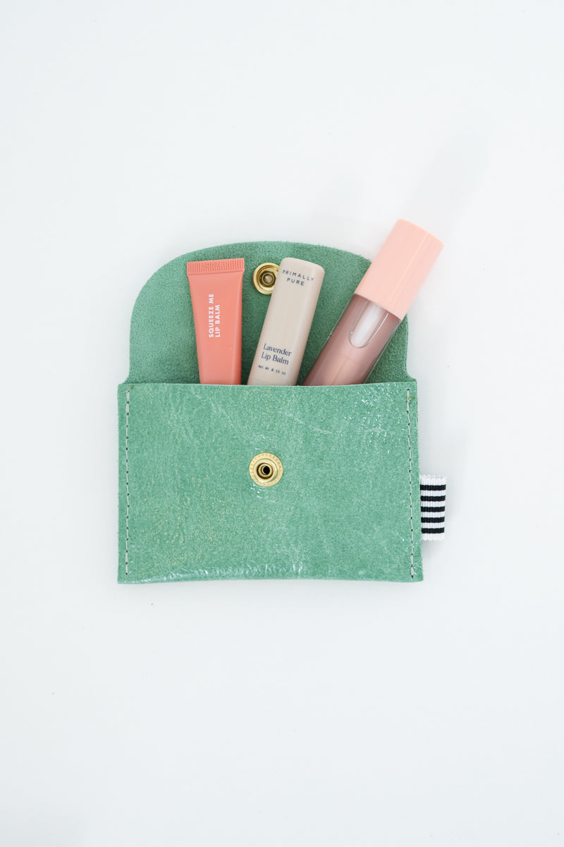 Green snap pouch with two lip balms and a lip gloss