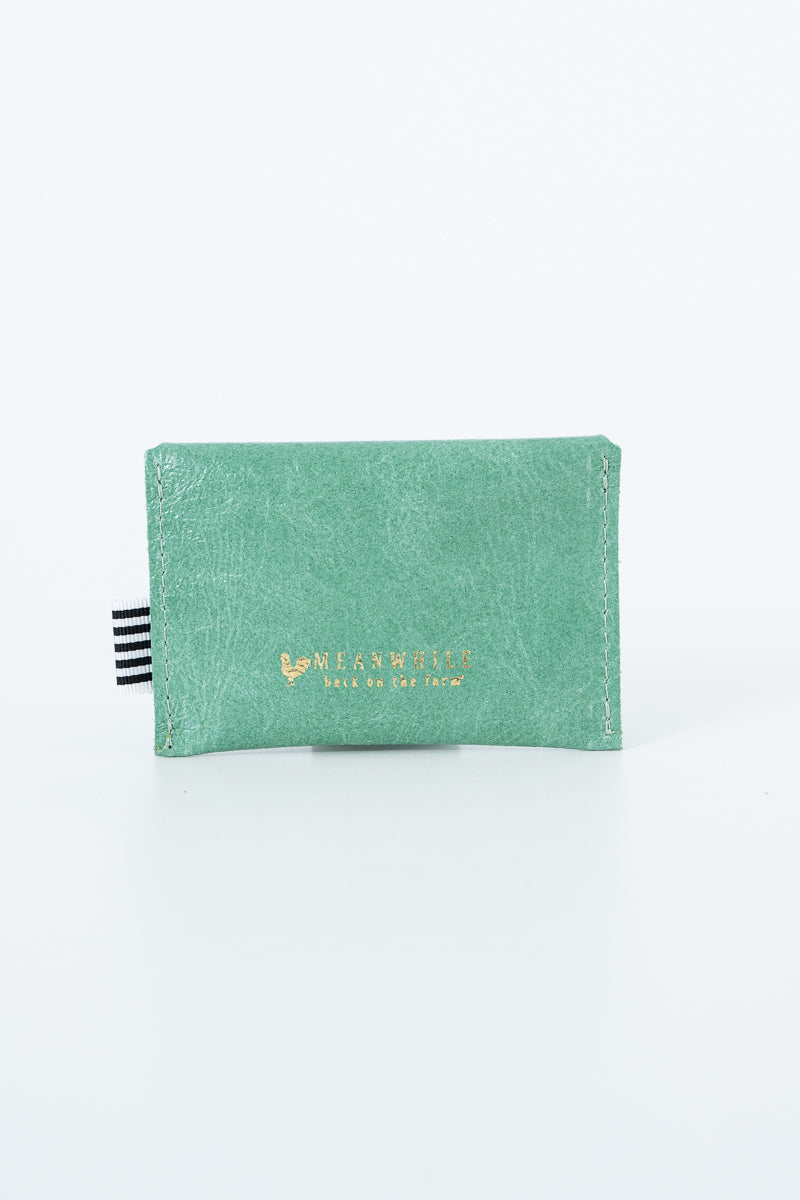 Green snap pouch with Meanwhile brand logo