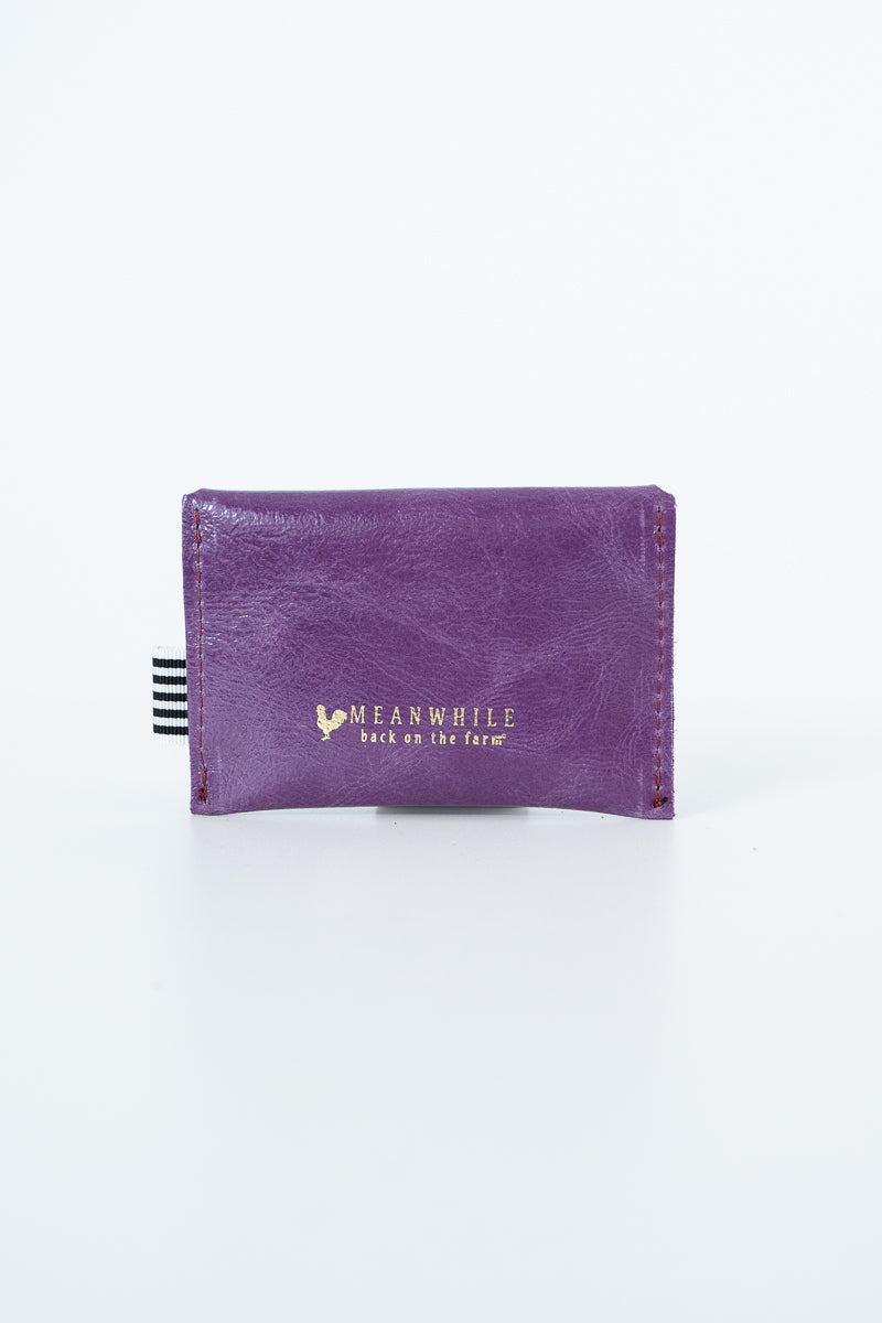Purple snap pouch with gold Meanwhile brand logo text