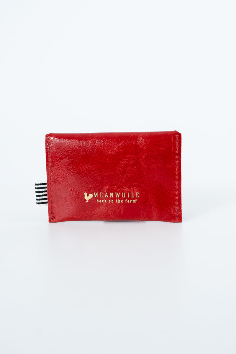 Red snap pouch with gold Meanwhile brand logo text