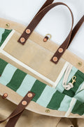 Beige tote bag with an interior green striped pattern and brown leather straps