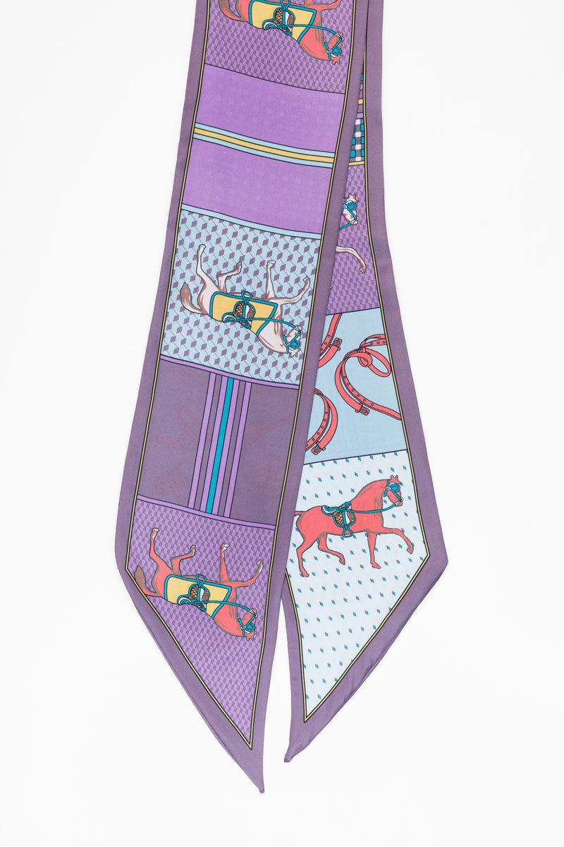 Scarf with purple, white and red themed derby pattern tied into a bow