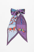 Scarf with purple, white and red themed derby pattern tied into a bow