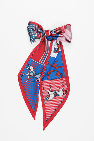 Scarf with red, white and blue derby themed pattern tied into a bow