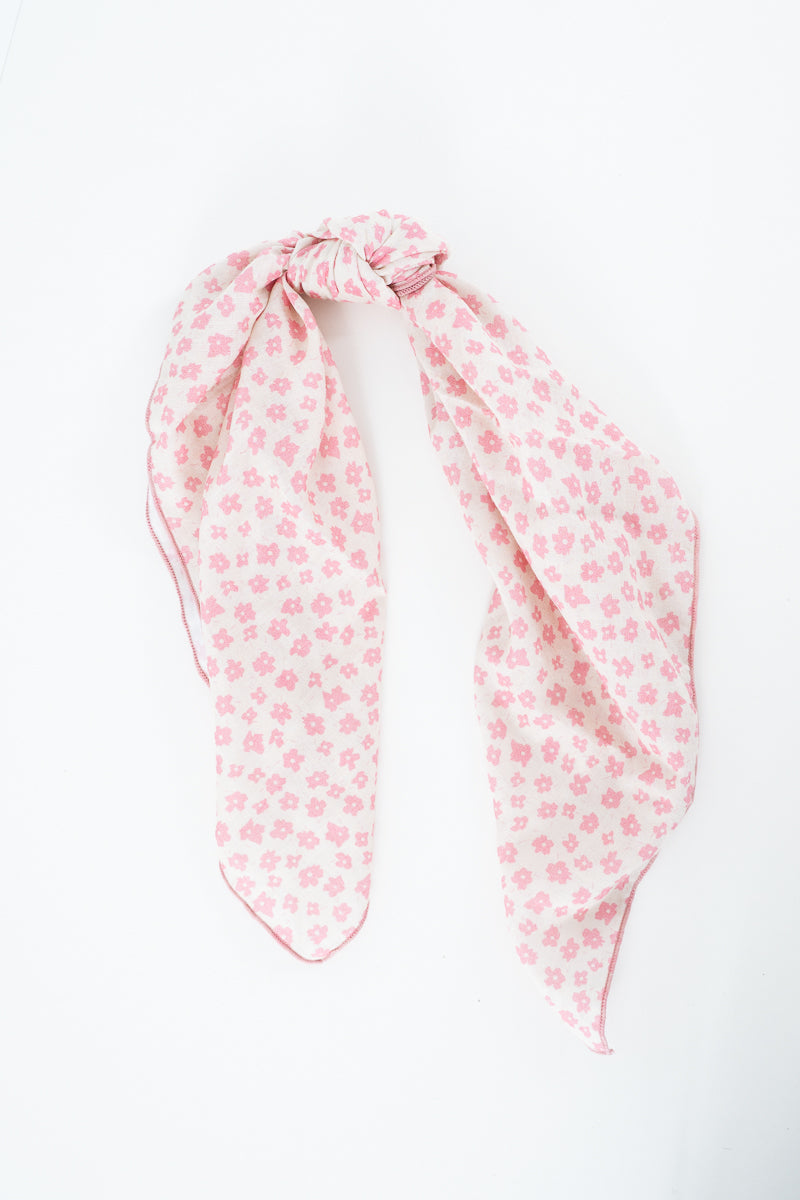 A light pink scarf with a small repeating floral pattern, tied in a knot at the top and laid flat on a white background. Handmade by Meanwhile Back on the Farm in Lynchburg,VA