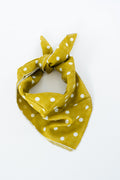 A saffron yellow scarf with white polka dots, tied in a knot on a plain white background. Handmade by Meanwhile Back on the Farm in Lynchburg,VA