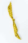 A saffron yellow scarf with white polka dots, tied in a knot and displayed diagonally on a clean white background. Handmade by Meanwhile Back on the Farm in Lynchburg,VA