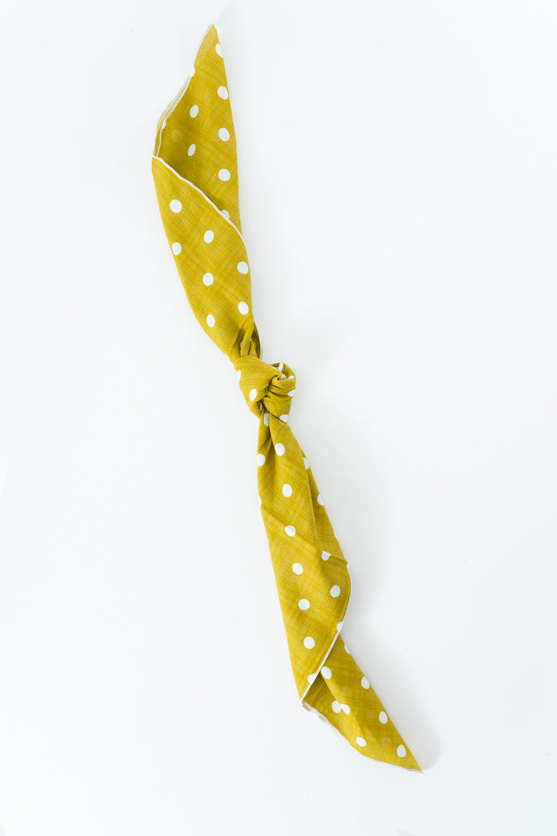 A saffron yellow scarf with white polka dots, tied in a knot and displayed diagonally on a clean white background. Handmade by Meanwhile Back on the Farm in Lynchburg,VA
