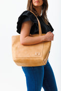 Woman holding natural Virginia leather signature tote bag