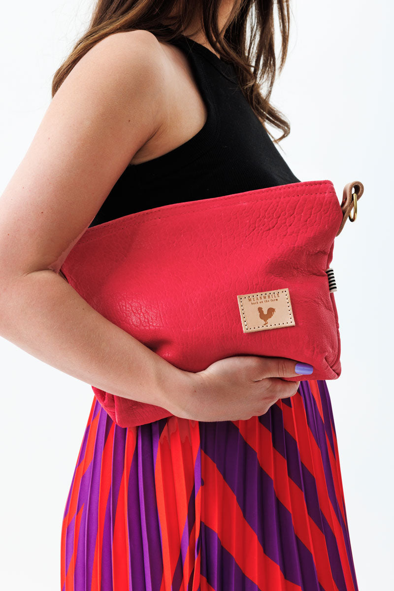 A women holding the bright pink bag with the meanwhile logo.