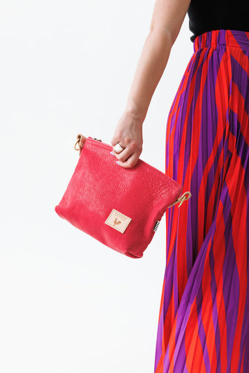 A women holding the bright pink bag with the meanwhile logo.