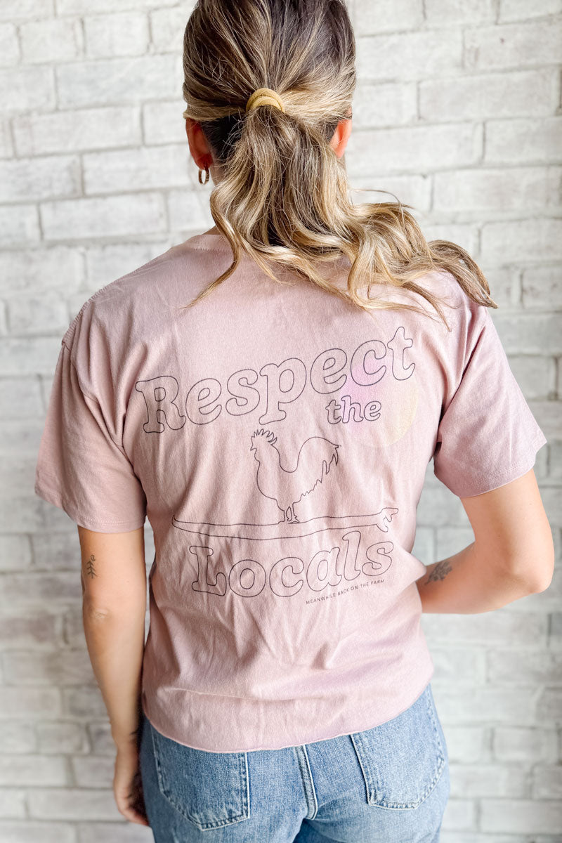 The front and back of a pink t-shirt that says respect the locals in black letters and a logo of a rooster and a surfboard
