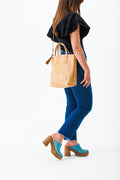 Woman holding natural Virginia leather small tote bag
